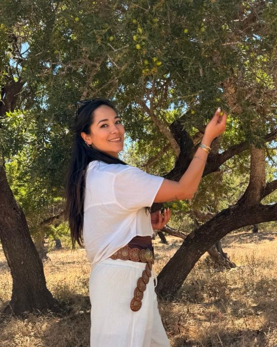 Soukaina, fondatrice di Berber Oro del Deserto, sotto un albero di argan in Marocco